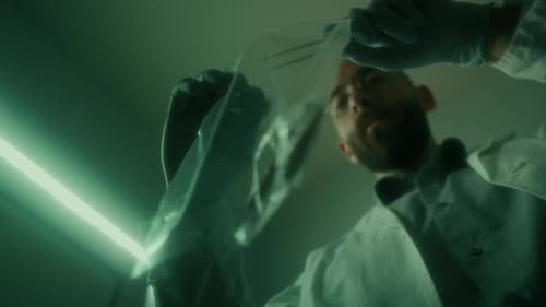Low Angle of Forensic Specialist Collecting Evidence into Plastic Bag