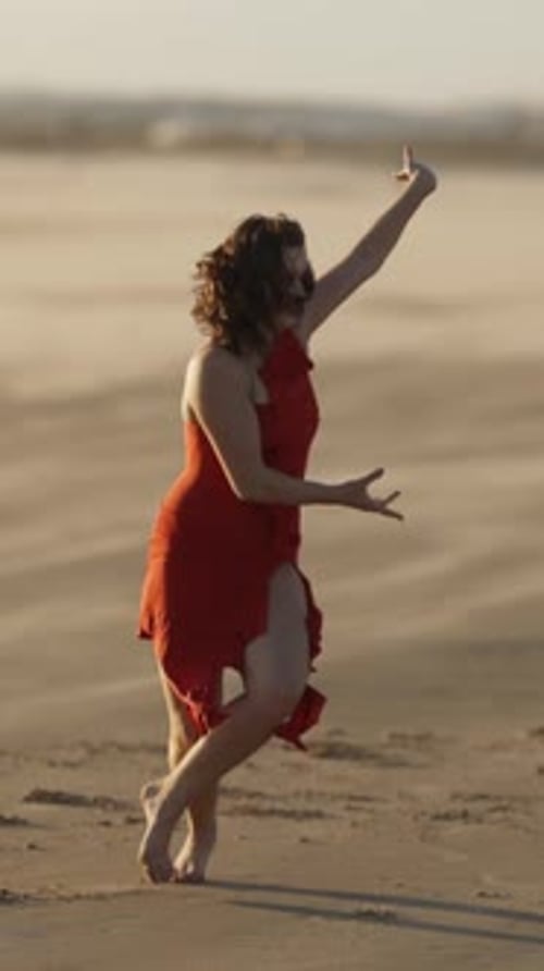 Woman Dancing on the Beach in Red Dress