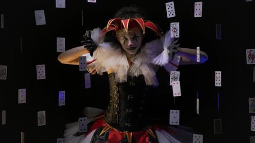Une joker avec un superbe maquillage blanc et noir sépare quelques cartes et jette un coup d'œil