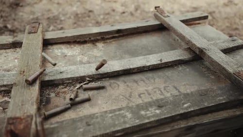 Bullets Fall onto a Weathered Wooden Box