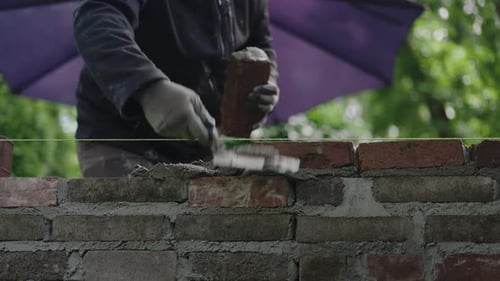 Bricklayer Building a Brick Wall Outdoors