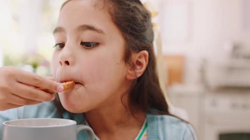 Young Girl Eating a Cookie Inside a Home