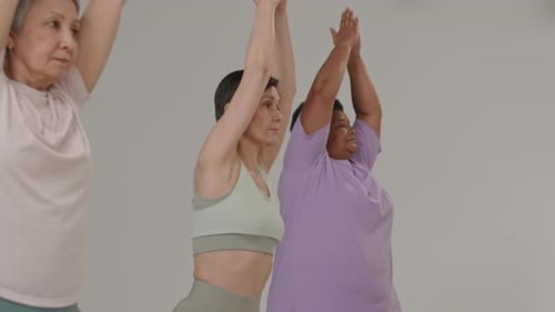Senior Women Practicing Warrior Pose during Yoga Class