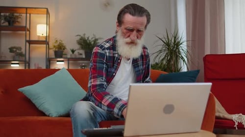 Senior Man Frustrated with Laptop at Home