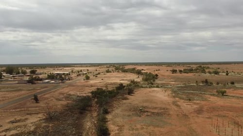 Drone ascending over deserted landscape showing a very small Australian outback town