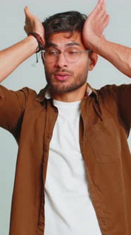 Man with headache holding hands on his head