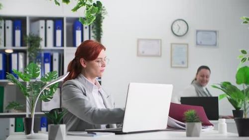 Ambiance de travail Jeune femme à lunettes occupée à travailler à rédiger des rapports Antécédents de la femme