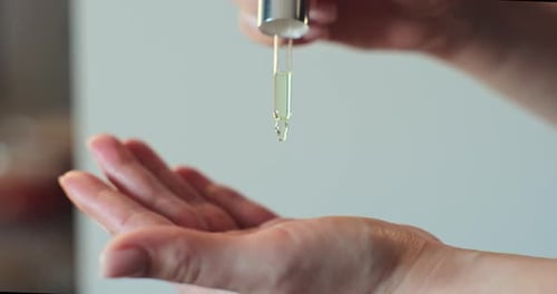 Woman Drips Cosmetic Oil on Her Hand From a Pipette Skin Care Beauty and Spa at Home