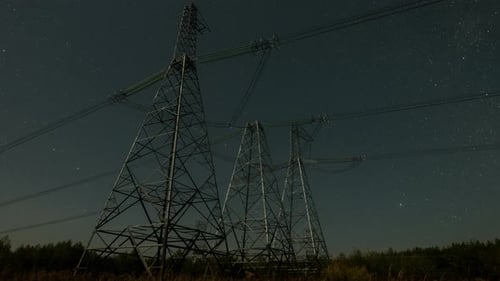Nighttime View of Power Lines Against a Starry Sky with Clear Visibility of Electrical Towers