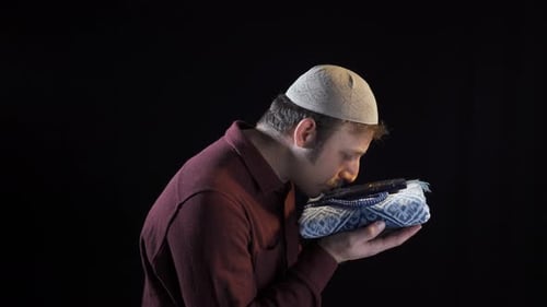 Man Holding Prayer Rug and Beads in Studio