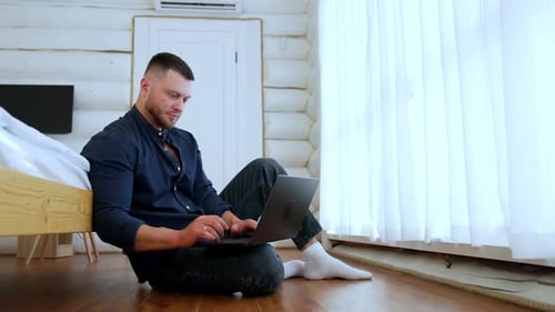Young Adult Using Laptop in Cozy Home Interior
