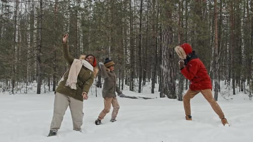 Friends and Family Have a Snowball Fight in Forest