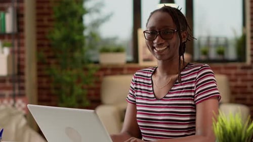 Smiling Woman Works on Laptop at Home