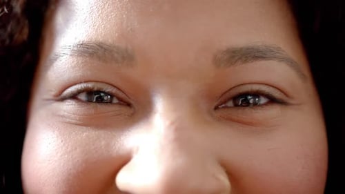 Portrait close up of eyes of happy african american woman smiling, slow motion