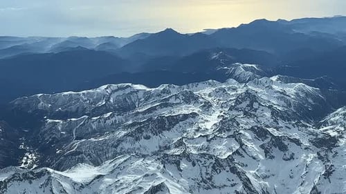 Vue latérale aérienne depuis le poste de pilotage d'un jet volant à 11000 m d'altitude au-dessus des Alpes françaises de l'est enneigées, près de Nic