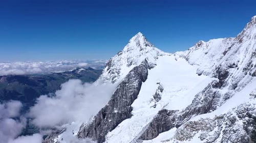 Clouds surrounding the peaks of a tall mountain