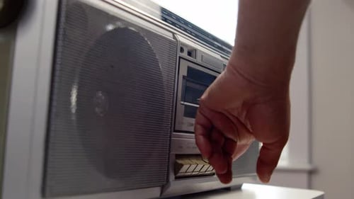 Primer plano de Boombox analógico pulsando con la mano Reproducir después de insertarlo