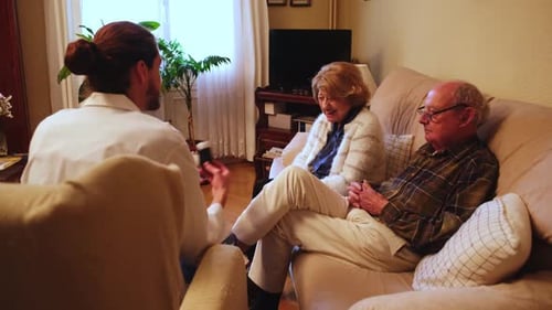 Young Adult Consults with Senior Couple at Home