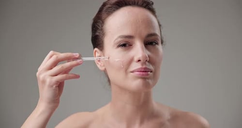 Woman Applies Serum with a Pipette in Studio