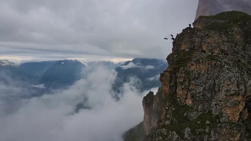 Slow Motion Aerial Man Jumping on a Rope Into an Abyss From a Cliff
