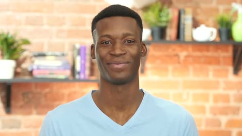 Young Adult Smiling in Front of Brick Wall