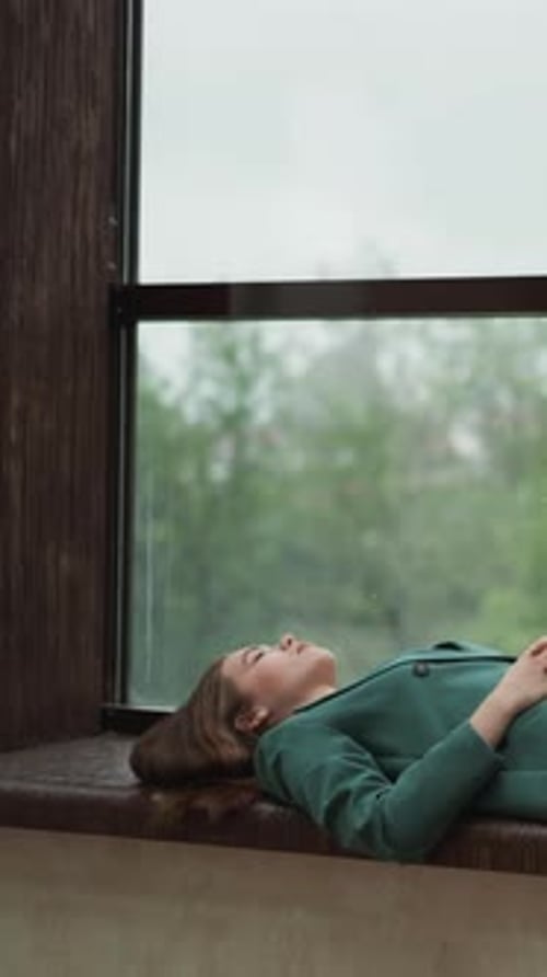 Woman Lying on Window Seat by Window