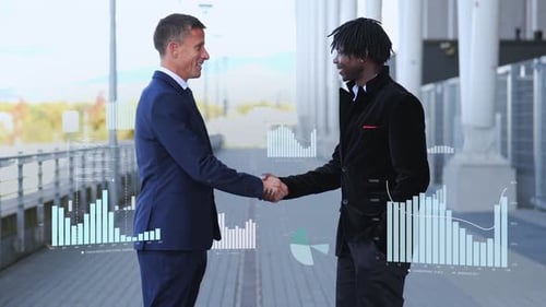 Businessmen Shaking Hands with Financial Charts Overlay