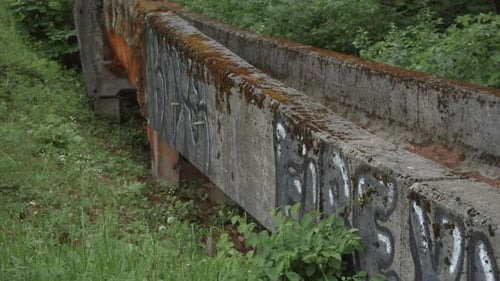 Tilt up to reveal old ruins of the Sarajevo olympic bobsleigh and luge track with a focus pull leadi