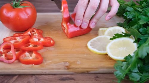 Hands Slicing Red Bell Pepper on Board