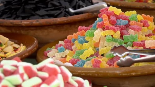 Delicious multi-colored candies. Bowls full of Colorful sweets candies for sale on the market. A pil
