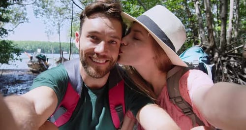 Happy couple takes selfie with tropical jungle background