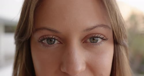 Nahaufnahme einer jungen Frau mit klarer Haut und entspanntem Gesichtsausdruck, häusliche Umgebung