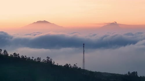 Stunning sunrise with the backdrop of Mount Merbabu and Mount Merapi_forward shot
