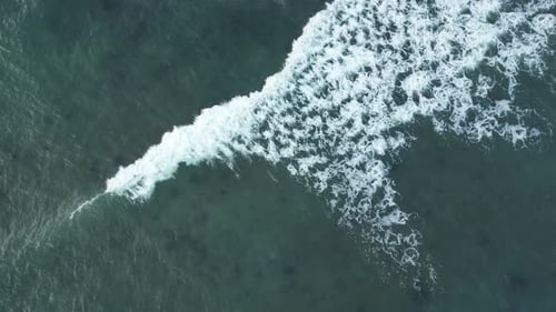 Wave foam moving on ocean surface, aerial footage.