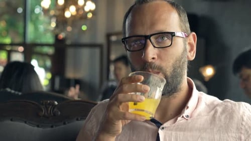 Young man enjoying a refreshing cocktail at a trendy cafe in town