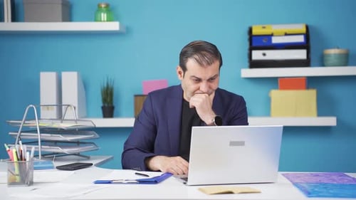 Frustrated Man Working on Laptop in Office