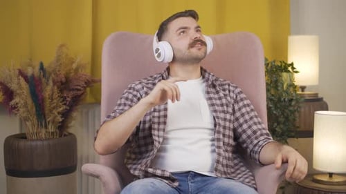 Man Listens to Music and Sings in Chair