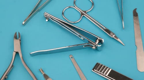 Shiny Manicure Tools on Light Blue Surface