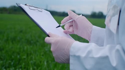 Botanist scientist analyzing plant crop making notes in a journal. Woman gardener biologist testing