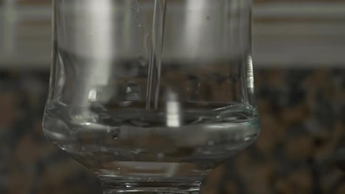 Water Pouring into a Glass Cup in Kitchen
