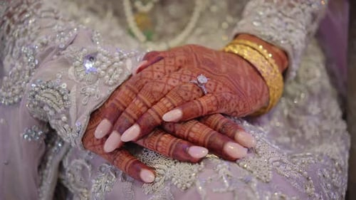 Mano nupcial tradicional pintada con henna con brazaletes dorados y anillo de compromiso