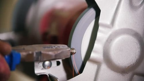 A Worker Making Angles on a Screw Using a Grinding