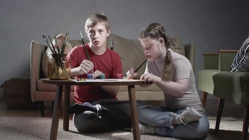 Young Man and Girl Painting Together at Home