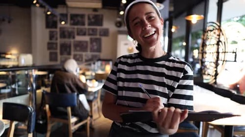 Smiling Woman Taking Orders in a Cafe