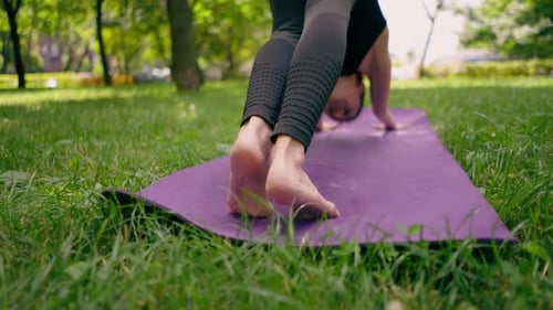 close-up athletic skinny pumped up legs of a woman standing with her feet on a mat for yoga