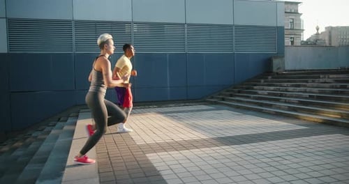 Athletic Man and Woman Running Stairs Outdoors