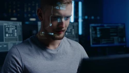 Portrait d'un développeur de logiciels/hacker travaillant sur un ordinateur personnel, numéros de code mobiles projetés