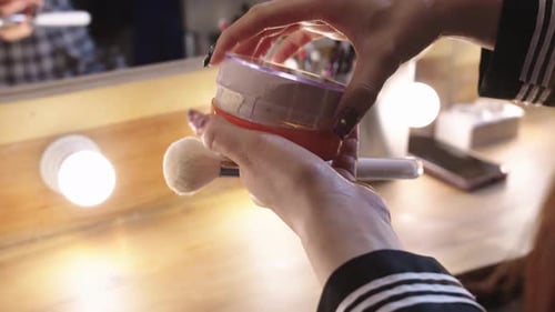 Cosmetic Artist Preparing Makeup Brush with Powder