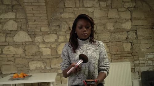 Woman Applying Makeup with Brush Indoors