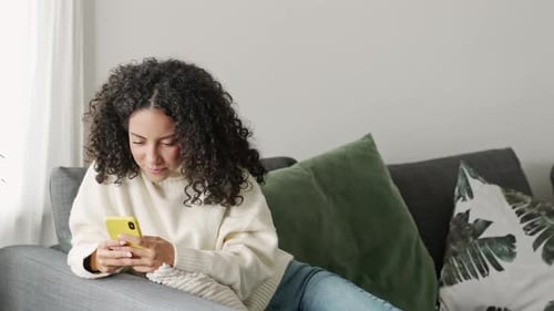 Woman Relaxing on Couch with Smartphone